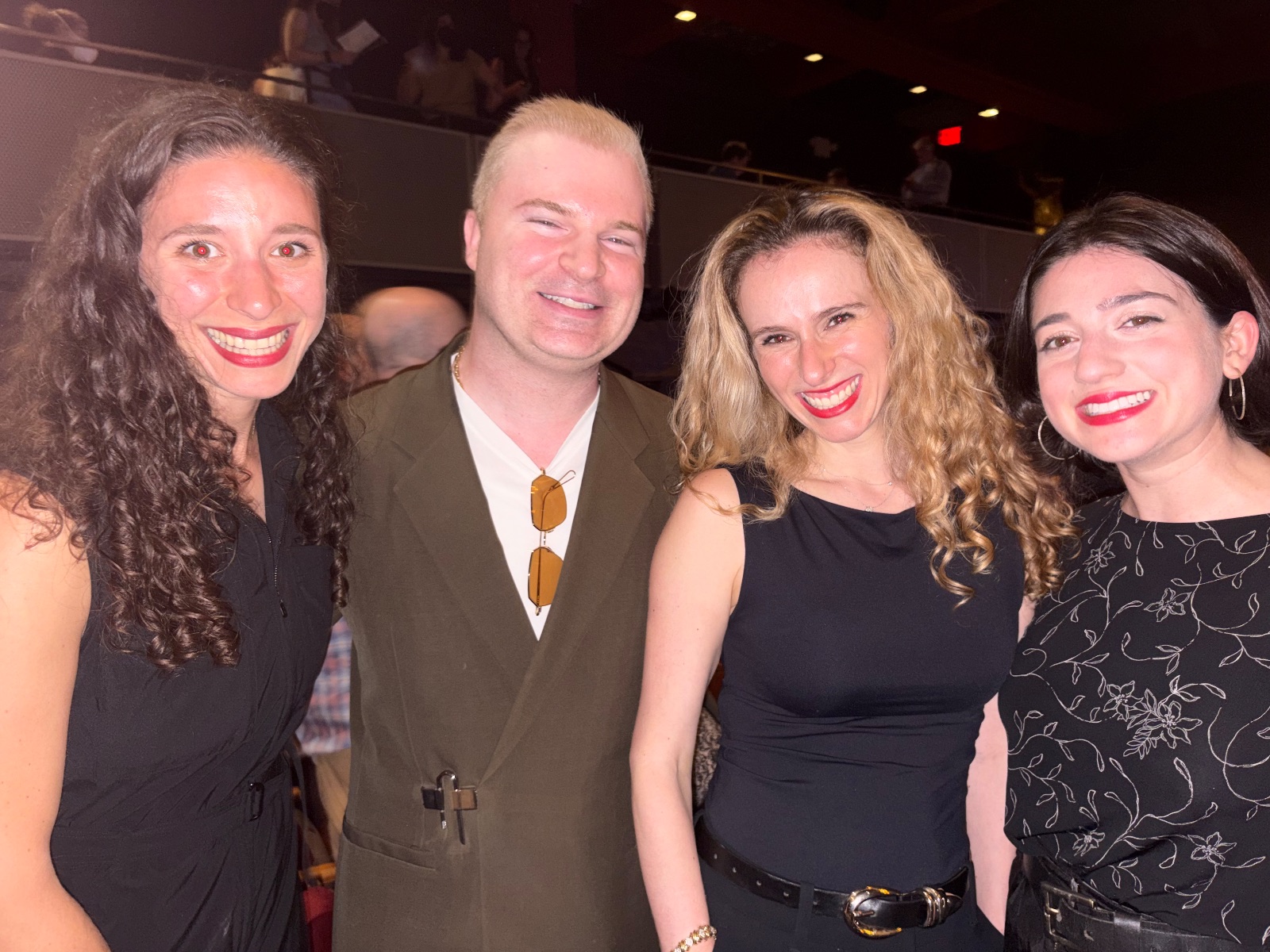 A group of people gathered together at an indoor social event, smiling and enjoying each other's company.