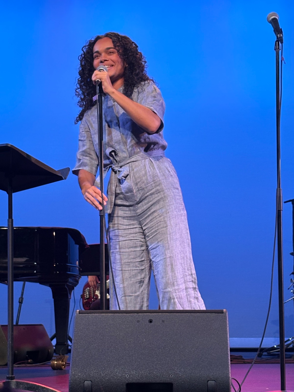 A musician performs on stage with professional lighting and instruments during an engaging musical performance.