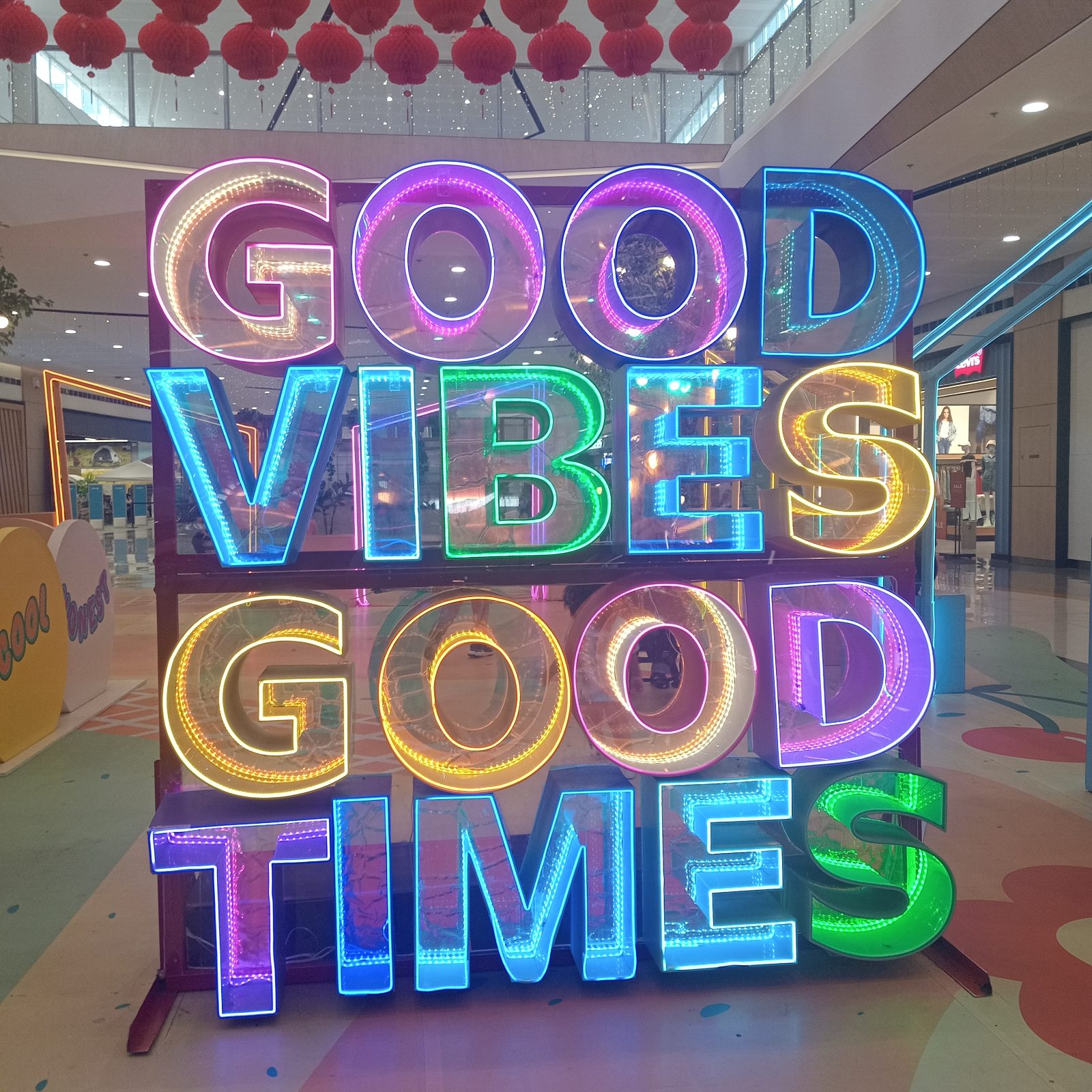 Vibrant neon signage displaying an uplifting message in colorful lights within an indoor space.